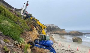 A construction vehicle stationed on a cliffside, highlighting its robust structure against a backdrop of scenic views.